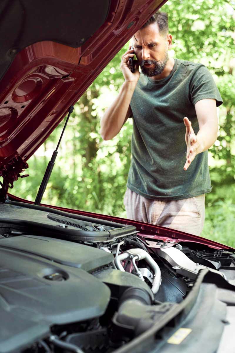 Junger Mann prüft Getriebeschaden bei Schrottauto Ankauf Bocholt